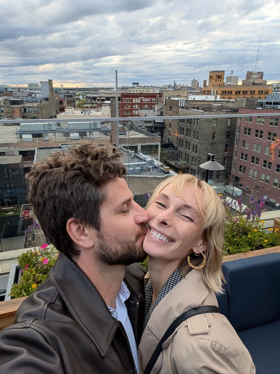 Sean and Ashley kissing, Milwaukee behind them.
